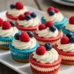 Red, White and Blue Mini Cheesecakes topped with whipped cream and berries