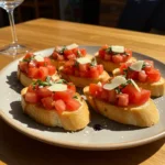 Close-up of traditional bruschetta with diced tomatoes, basil, Parmesan, and balsamic glaze on toasted baguette